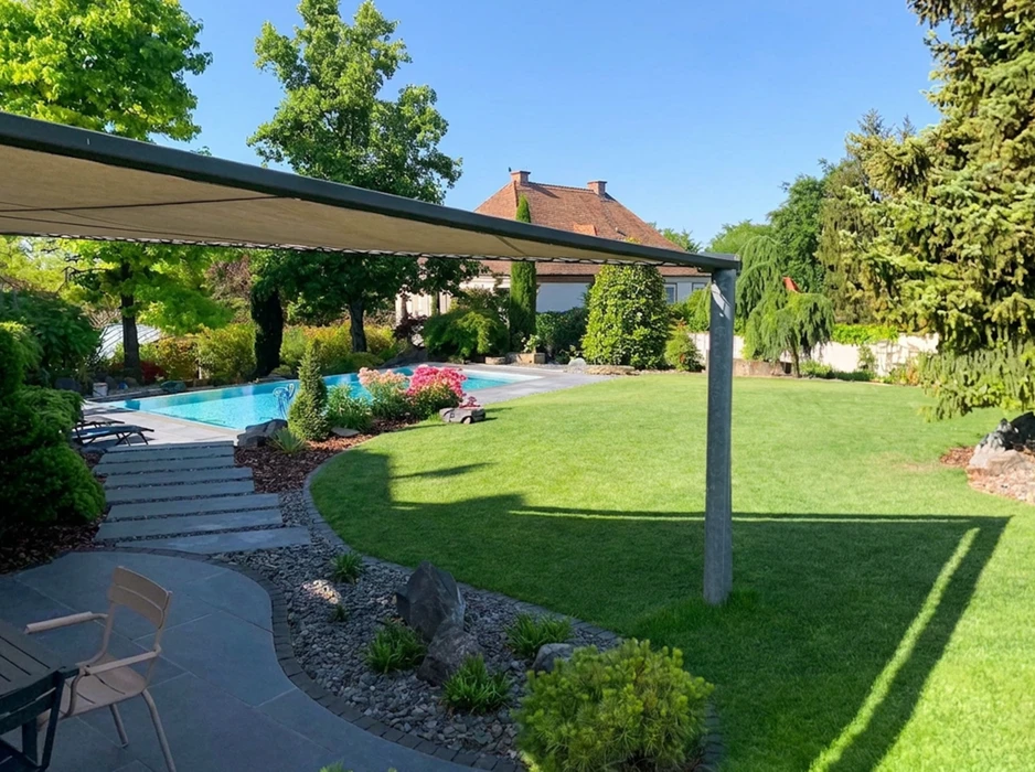 Espace piscine extérieur avec terrasse en travertin clair, piscine à débordement avec liner bleu mosaïque