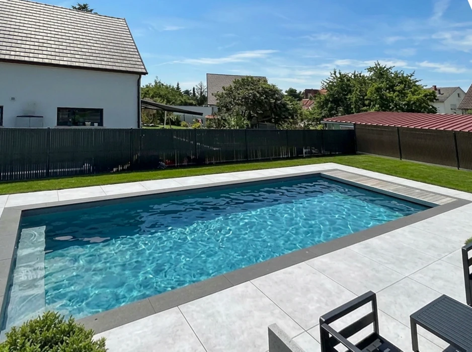 Piscine extérieure octogonale à débordement partiel, eau turquoise cristalline, revêtement liner blanc marbré