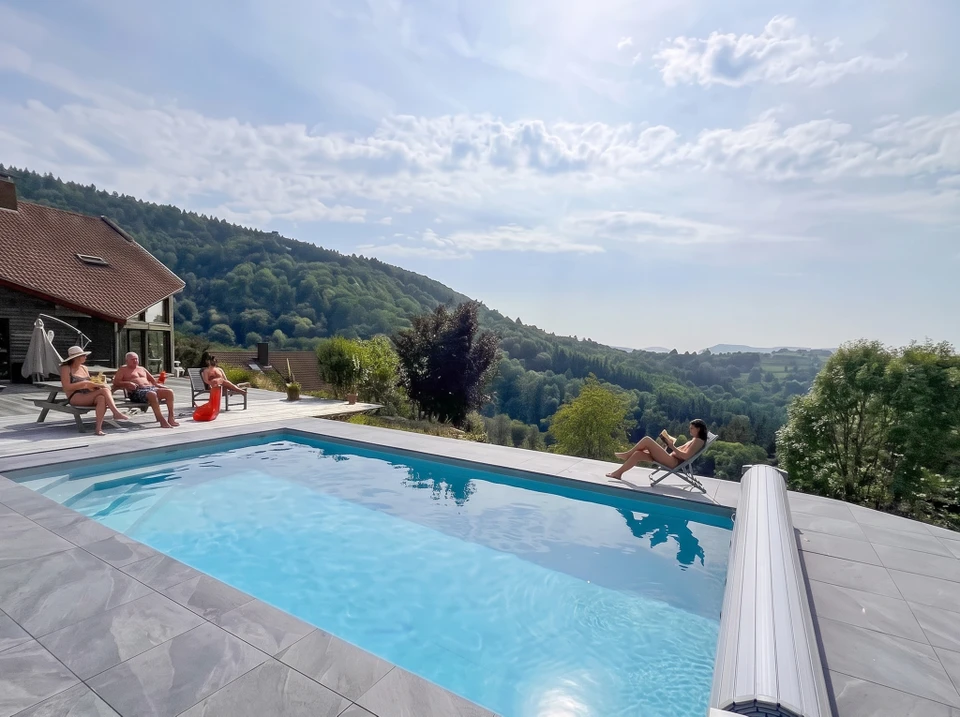 Piscine rectangulaire enterrée en milieu résidentiel, jardin verdoyant ensoleillé