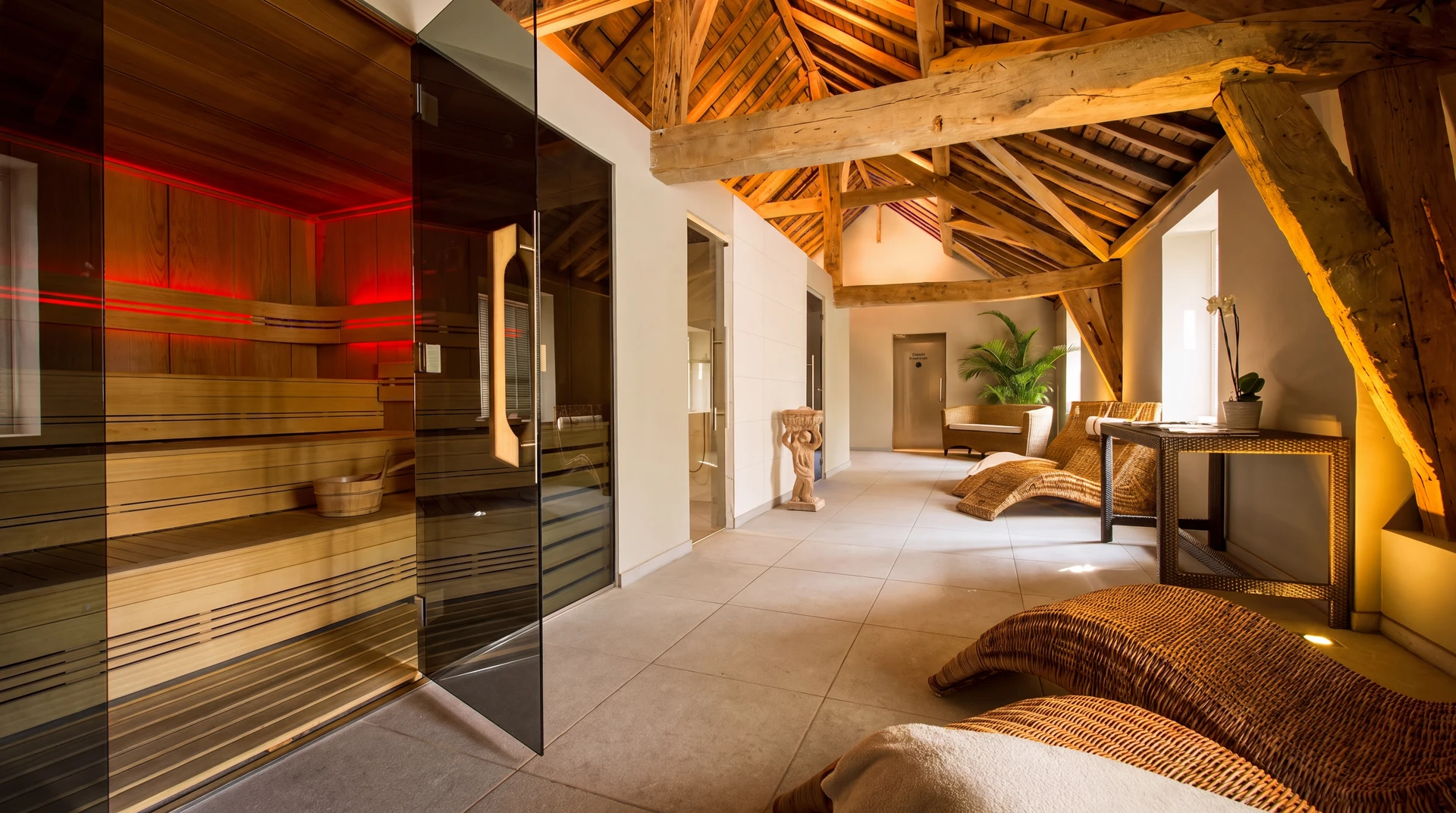 Espace spa haut de gamme avec lits de repos rembourrés couleur taupe, agrémentés de coussins et serviettes